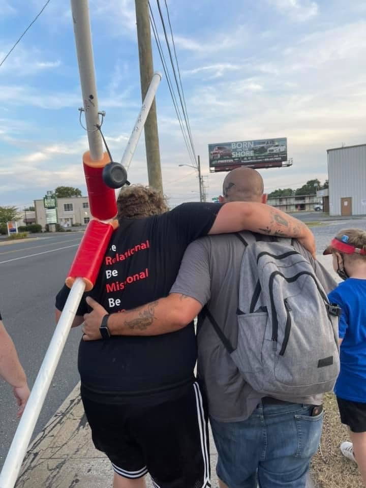 At right Rob Stockman, who was recently baptized alongside his father and daughter at Canvas Church, helps Pastor Richard Pope after Pope’s hip dislocated about a mile from the finish line.   This photo is being used for non-commercial purpose and not in connection with selling a good or service.